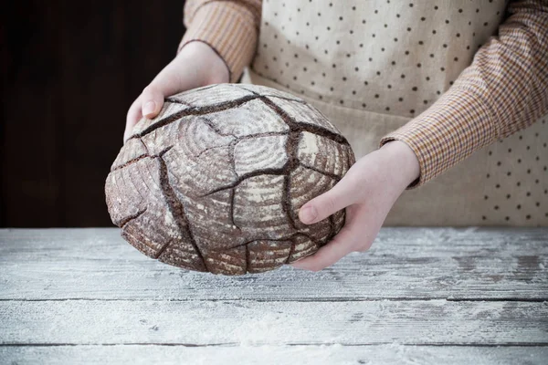 Mains avec du pain sur fond en bois — Photo