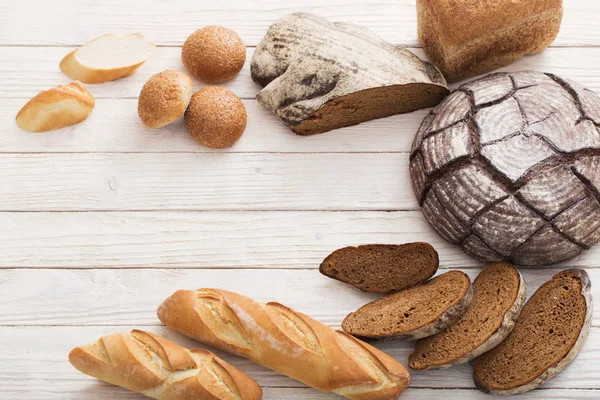 Different types of bread on wooden background — Stock Photo, Image