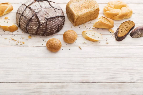 Diferentes tipos de pão no fundo de madeira — Fotografia de Stock