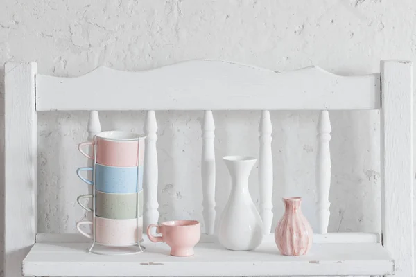 Чашки і ваза на старовинній білій полиці — стокове фото
