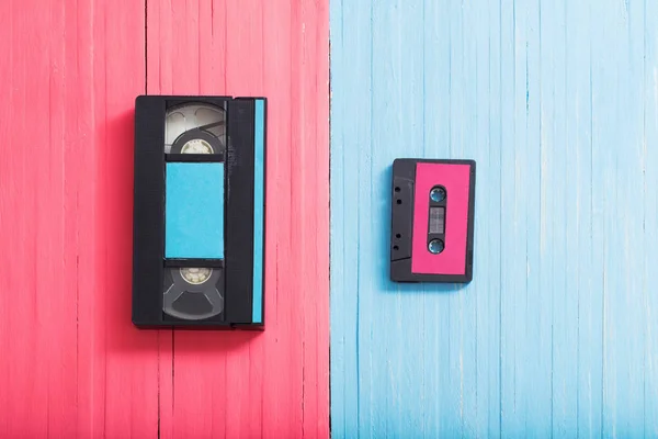 Cassette vidéo et cassette sur fond en bois rose et bleu — Photo