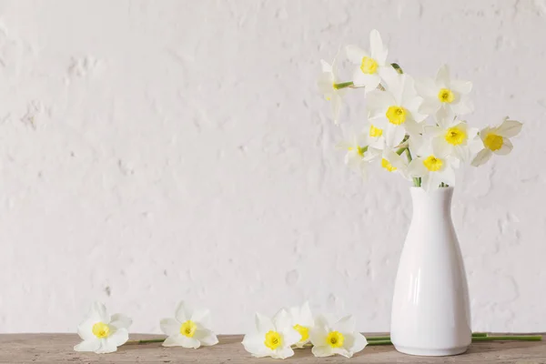 Narcisos en jarrón blanco sobre fondo blanco — Foto de Stock