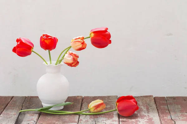 Tulips in vase on white old background — Stock Photo, Image