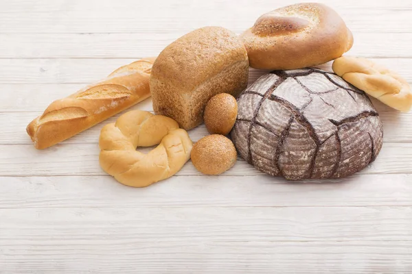 Diferentes tipos de pão no fundo de madeira — Fotografia de Stock