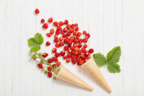 Waffelkegel mit Erdbeeren auf Holzgrund — Stockfoto