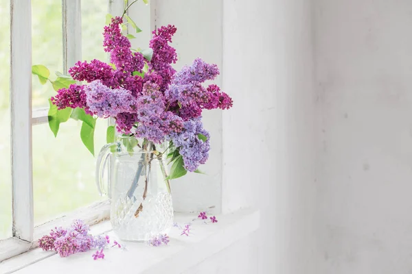 Ramo de lilas en una jarra de vidrio — Foto de Stock