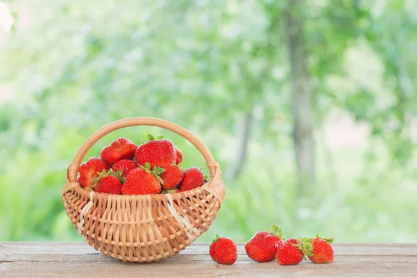 Erdbeere im Korb auf Holztisch im Freien — Stockfoto