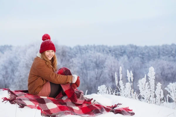 Teen girl on plaid in snow — Stock Photo, Image