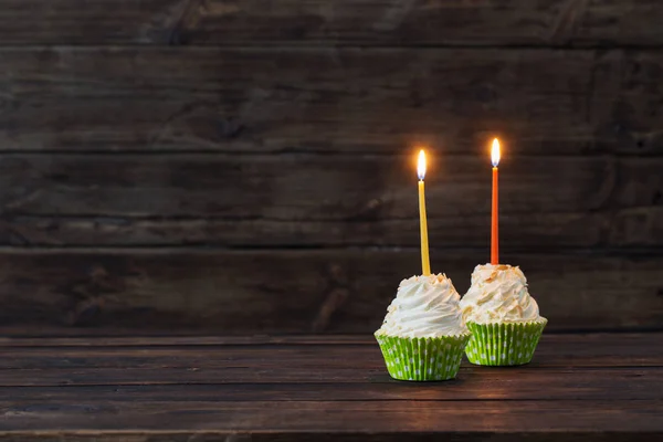 Cupcakes de cumpleaños con velas sobre fondo viejo de madera oscura —  Fotos de Stock