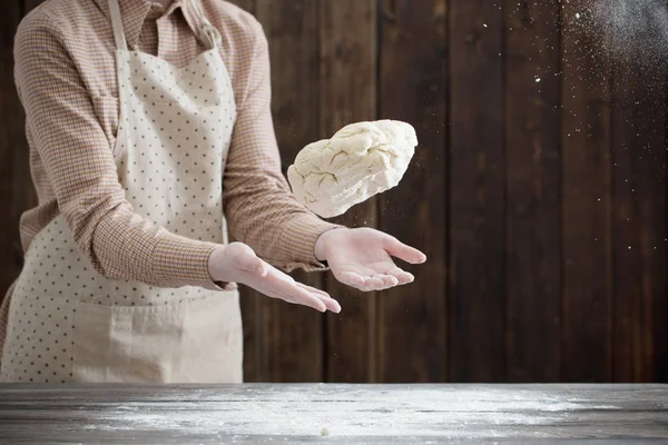 Hands cooking dough on dark wooden background — Stock Photo, Image