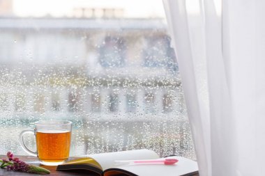 gün batımında yağmur damlaları ile pencere nin arka planda çay fincan