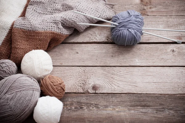 Knitting and knitting needles on a wooden surface