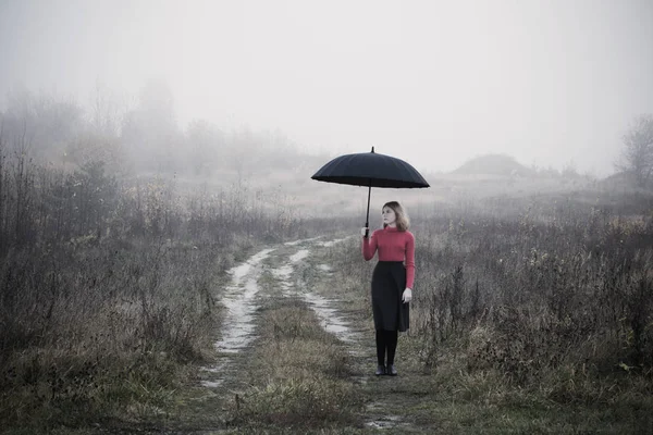 Fiatal lány őszi mezőben esernyő — Stock Fotó