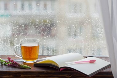gün batımında yağmur damlaları ile pencere nin arka planda çay fincan