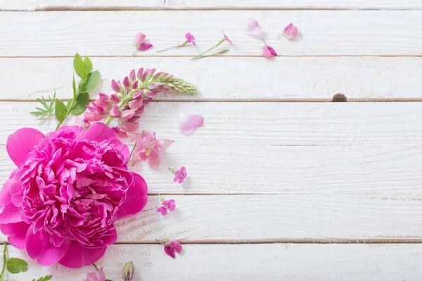 Рожеві красиві квіти на білому дерев'яному фоні — стокове фото