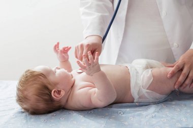 Doktor için küçük çocuk stetoskop ile dinler.
