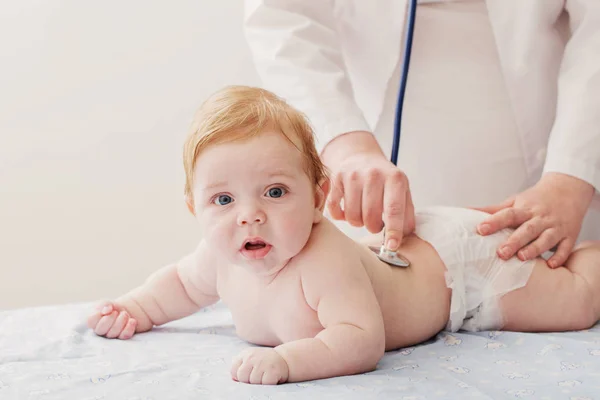 Лікар слухає маленьку дитину зі стетоскопом — стокове фото