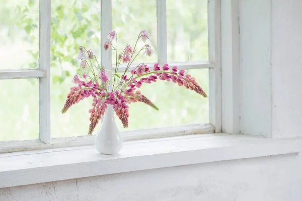 Fleurs d'été roses dans un vase sur le rebord blanc de la fenêtre — Photo