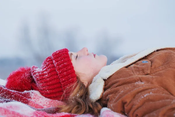 Teen girl on plaid in snow — Stock Photo, Image