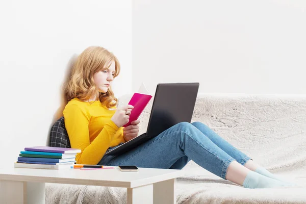 Chica adolescente estudiando y aprendiendo con cuaderno en casa. En línea —  Fotos de Stock