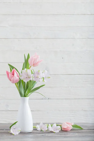 Spring flowers in white vase — Stock Photo, Image