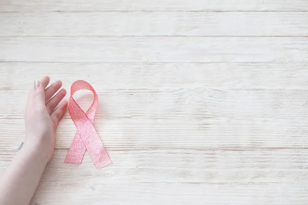 Nastro rosa in mano come simbolo di lotta contro il cancro al seno — Foto Stock