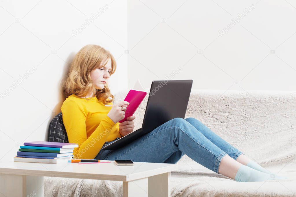 Teen girl studying and learning with  notebook at home.  Online 