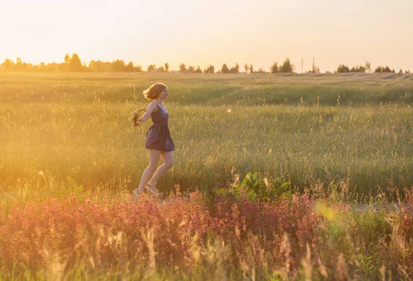 Έφηβος κορίτσι στο καλοκαίρι πεδίο στο ηλιοβασίλεμα — Φωτογραφία Αρχείου