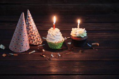 eski koyu ahşap arka plan üzerinde mum ile doğum günü cupcakes
