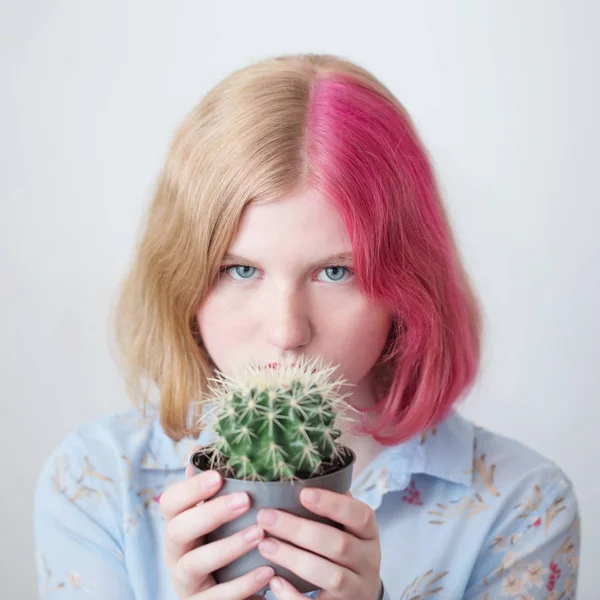 Triste adolescente chica holding cactus en flor olla —  Fotos de Stock
