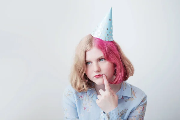 Sad teenager girl in birthday hat — Stock Photo, Image