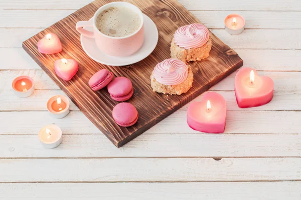 Tasse de café avec des gâteaux et des bougies brûlantes sur ba en bois blanc — Photo