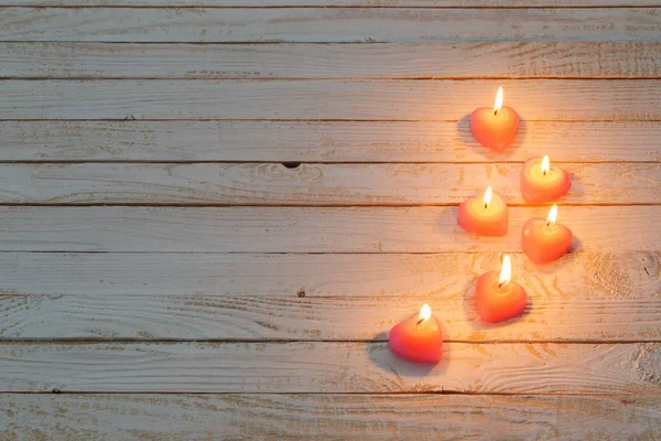 Velas ardientes de color rosa sobre fondo de madera blanco — Foto de Stock