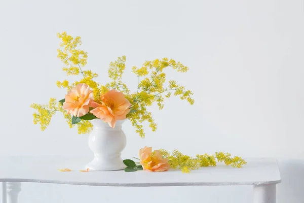 Rosas naranjas con flores silvestres en ramillete en jarrón blanco en medio — Foto de Stock