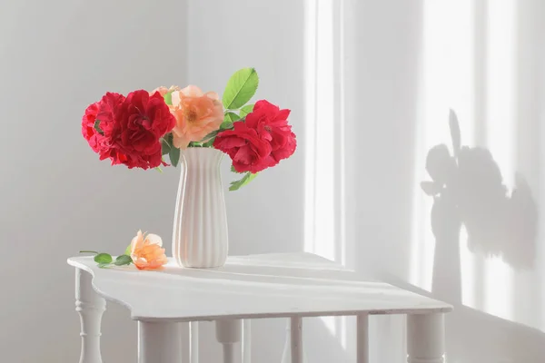 Rosas em vaso no interior branco — Fotografia de Stock