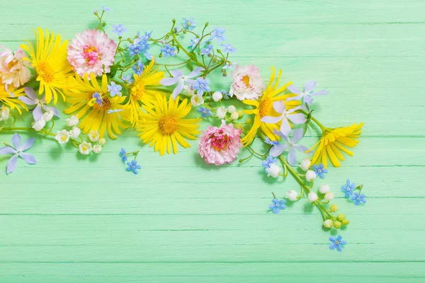 Marco de hermosas flores sobre fondo de madera verde — Foto de Stock