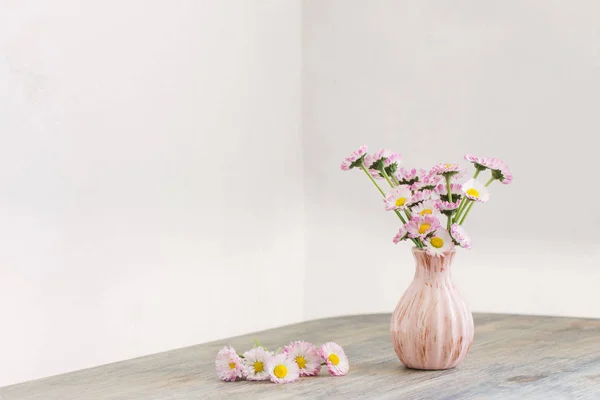 Fiori di margherita in vaso rosa su tavolo di legno — Foto Stock
