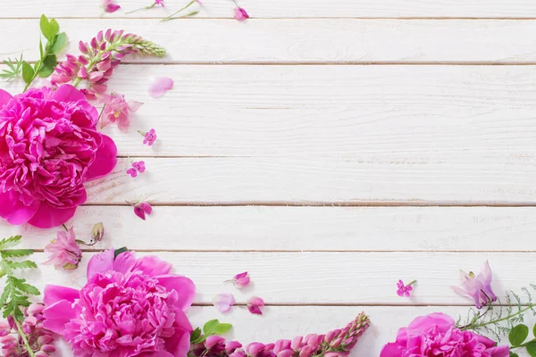 Růžové nádherné květiny na bílém dřevěném pozadí — Stock fotografie