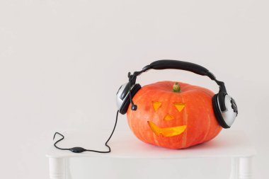Beyaz arka planda kulaklıkile Halloween kabak