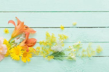 yeşil ahşap arka planda sarı ve turuncu çiçekler