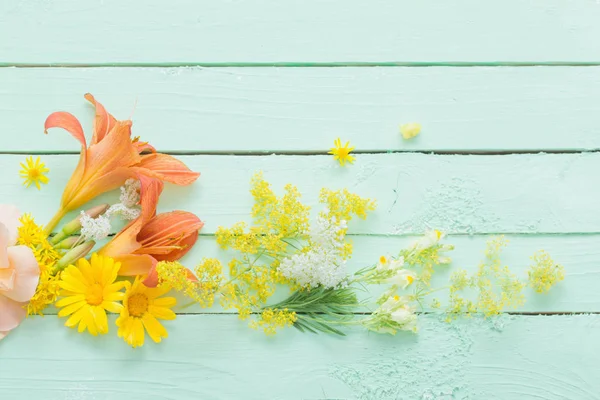 Flores amarillas y anaranjadas sobre fondo de madera verde —  Fotos de Stock
