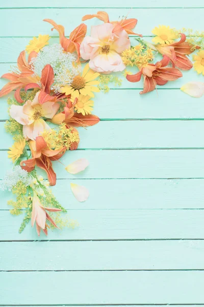 Fiori gialli e arancioni su sfondo verde in legno — Foto Stock