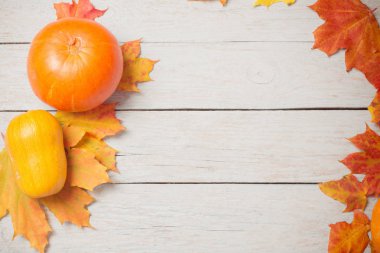 eski beyaz ahşap backgroun üzerinde sonbahar yaprakları ile turuncu kabak