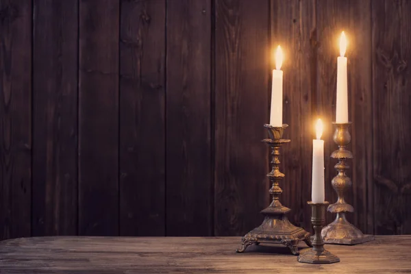 Burning candle on old wooden background — Stock Photo, Image