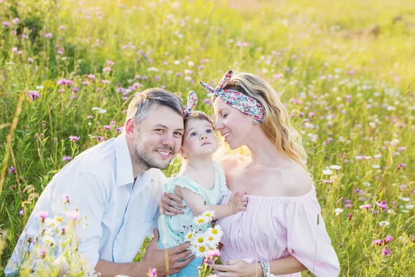 Família feliz no prado de flores — Fotografia de Stock