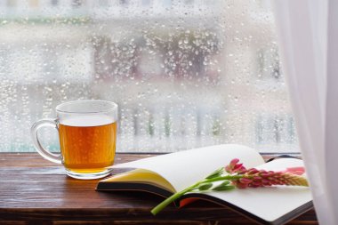 gün batımında yağmur damlaları ile pencere nin arka planda çay fincan