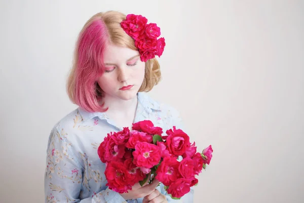 Giovane ragazza con rose rosse su sfondo bianco — Foto Stock