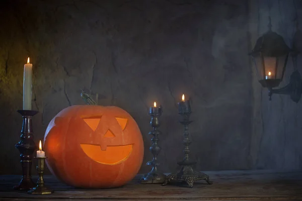 Halloween dýně na dřevěný stůl na tmavém pozadí — Stock fotografie