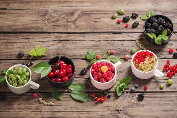 Verschiedene Beeren auf altem Holzgrund — Stockfoto