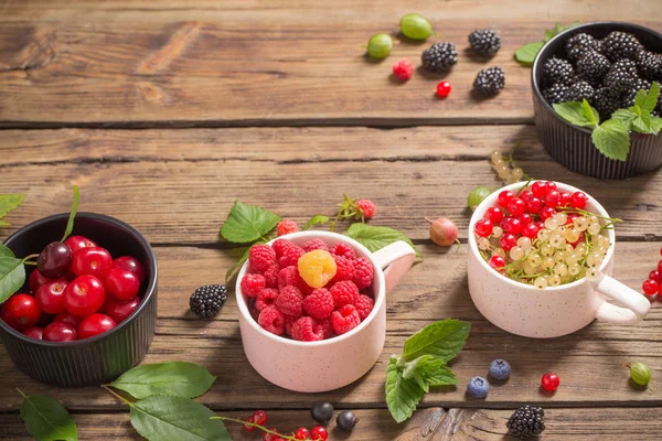 Verschiedene Beeren auf altem Holzgrund — Stockfoto